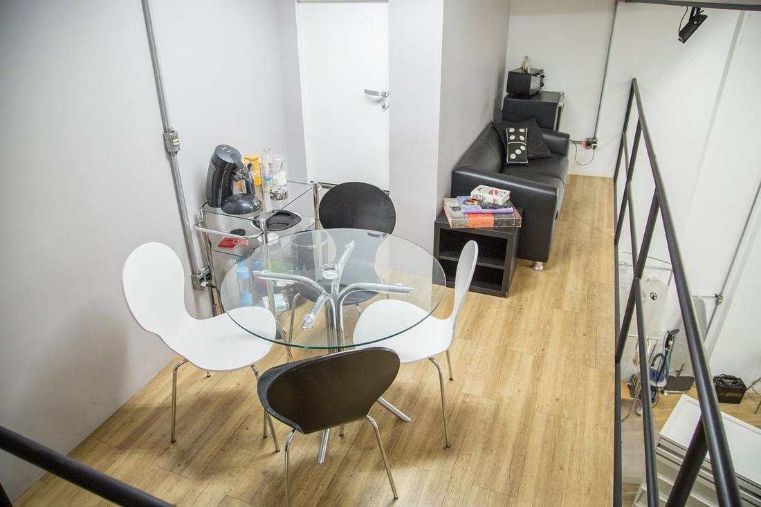 Mezanino com mesa de vidro, cadeiras, cafeteira e frigobar